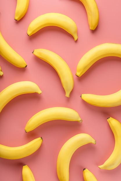 Geometric pattern of bananas on a pink background. the view from the top. minimal flat style. pop art design, creative summer concept