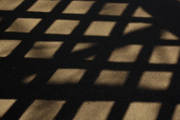 Geometric shadows from the grid on the ground view from above background texture