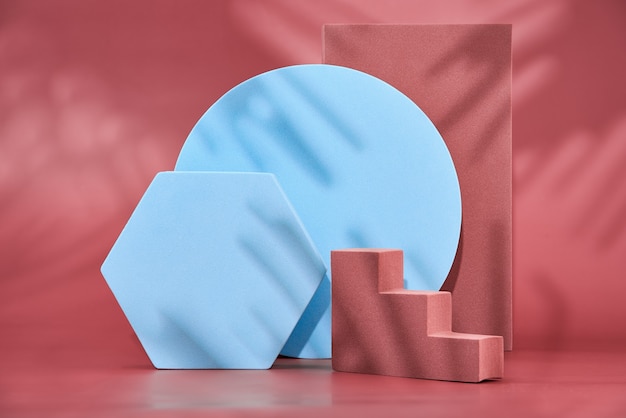 Photo geometric shapes on a red wall, empty podiums for the presentation of various products, abstract geometric wall with a pedestal