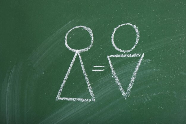 geometric silhouettes of a man and a woman drawn in chalk gender symbols and an equal sign gender equality