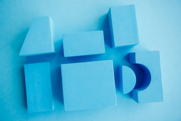 Photo geometrical figures still life composition. cube and other objects on blue background.