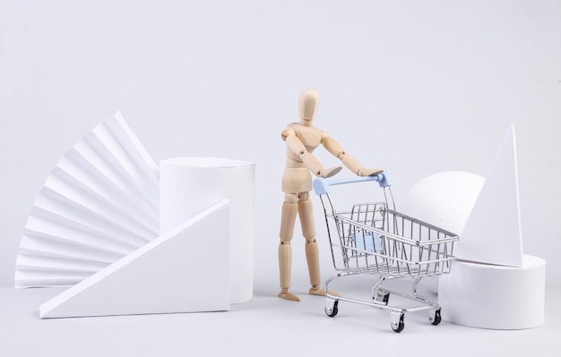 Foto geometrische vormen en marionet met winkelwagentje op witte achtergrond minimalism sale showcase