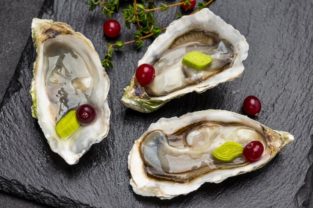 Geopende oesterschelpen op zwarte achtergrond Plat leggen