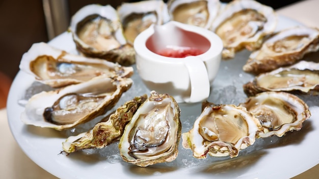 Geopende verse oesters met citroen op schotel Ondiepe dof