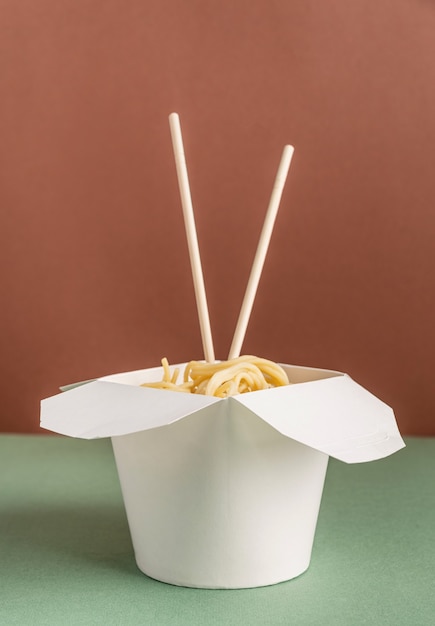 Foto geopende wok-kartonnen doos met noedels en eetstokjes voor mock-upontwerp