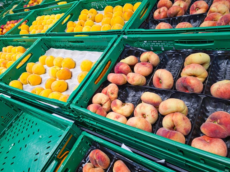 Georganiseerde oranje en gele perziken in de supermarkt. Fruit en vitamines