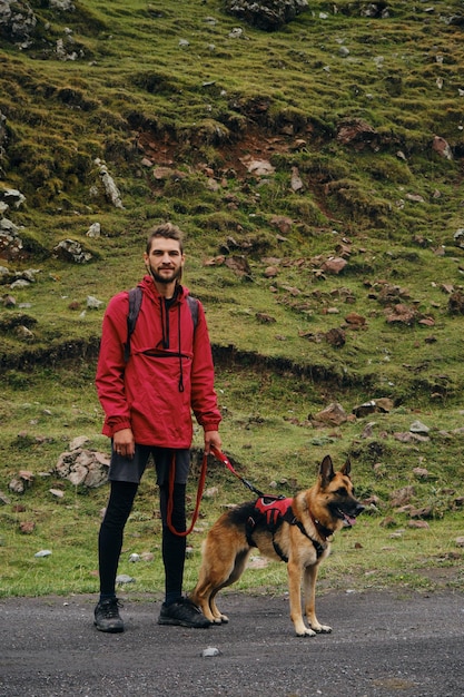 Georgia Kazbegi region A young nomad guy went hiking with a dog A male traveler