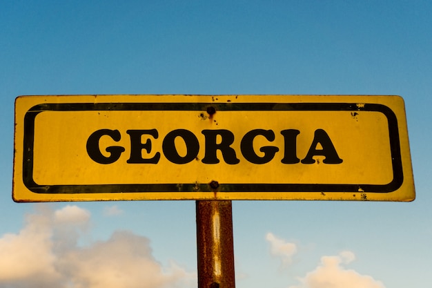 Georgia state  on old yellow sign with blue sky 