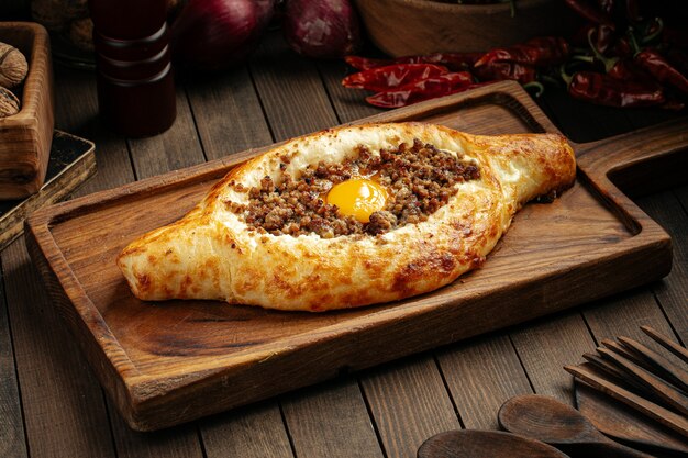 Foto khachapuri adjarian georgiano con uova e carne macinata