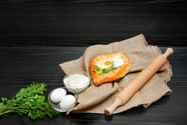 Georgian cuisine, Khachapuri on sackcloth, flour, eggs and rolling pin.