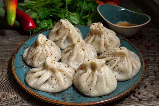 Georgian dumplings khinkali meat-filled on a ceramic plate sprinkled with ground pepper