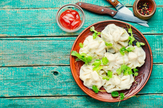 Georgian dumplings khinkali with meat, greens and tomato sauce