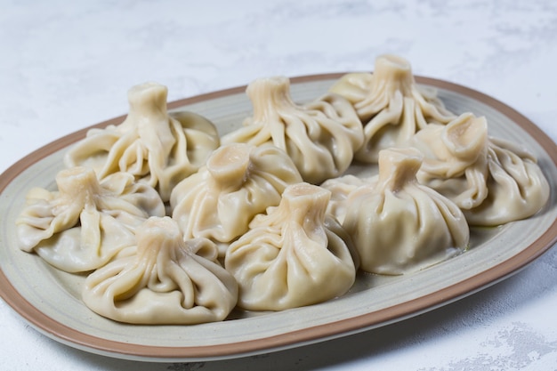 Georgian dumplings Khinkali with meat on white plate.