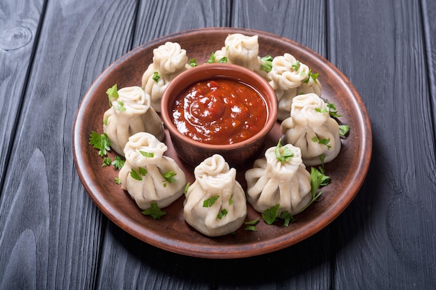 Georgian dumplings khinkali with tomato sauce and parsley