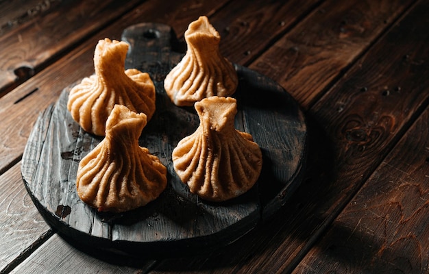 Georgian fried khinkali dumplings with meat on a wooden plank A traditional dish of Caucasian cuisine High quality photo