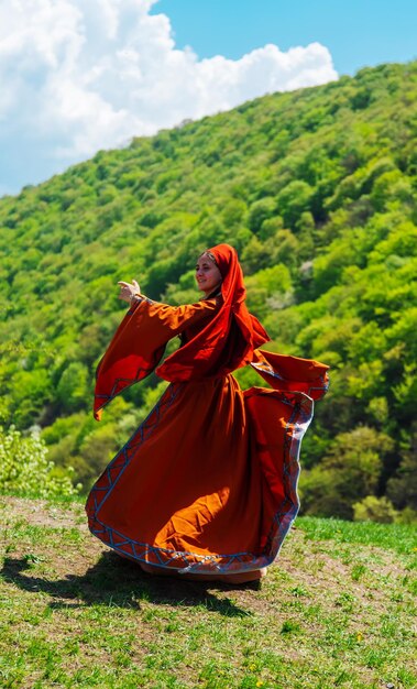 Georgian girl in national costume dances Georgian national dances selective focus