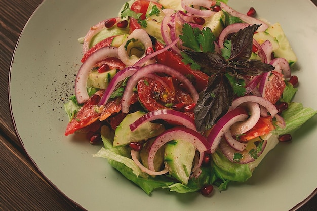 Georgian vegetable salad tomatoes with cucumbers red onion walnut pomegranate seeds top view no people