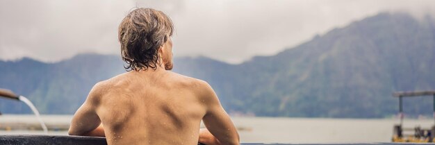 Geothermal spa man relaxing in hot spring pool young man enjoying bathing relaxed in a blue water