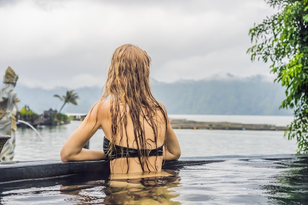 Geothermische spa Vrouw ontspannen in warmwaterbron zwembad tegen het meer warmwaterbronnen concept