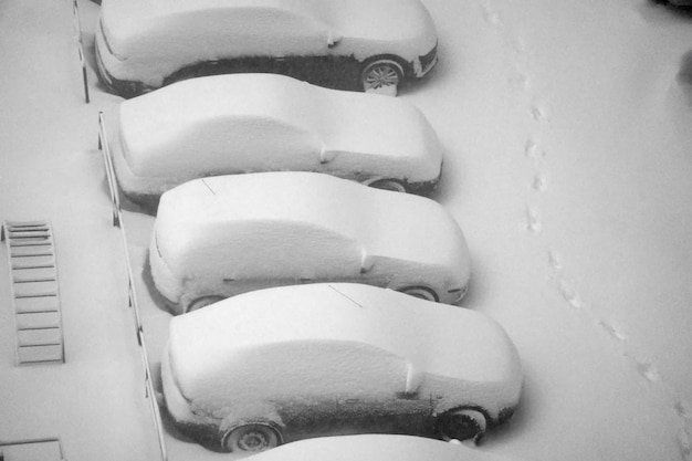 Geparkeerde auto&#39;s bedekt met sneeuw schot van bovenaf arieal winter stedelijk probleem