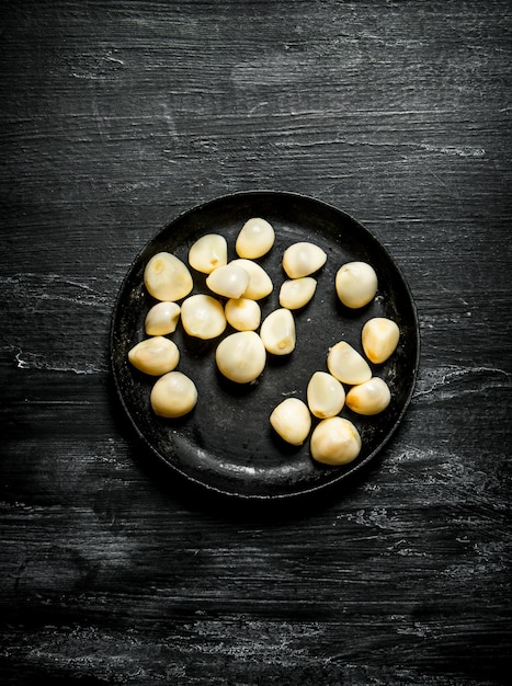 Gepelde knoflook in een oude pan