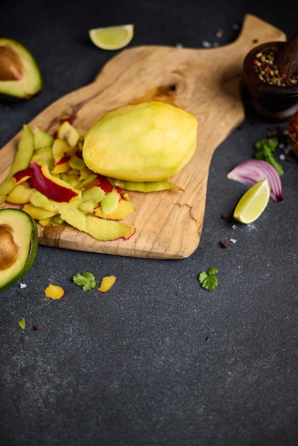 Gepelde mango op een houten snijplank in de huishoudelijke keuken