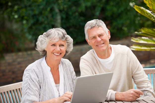 Gepensioneerd paar dat aan hun laptop werkt