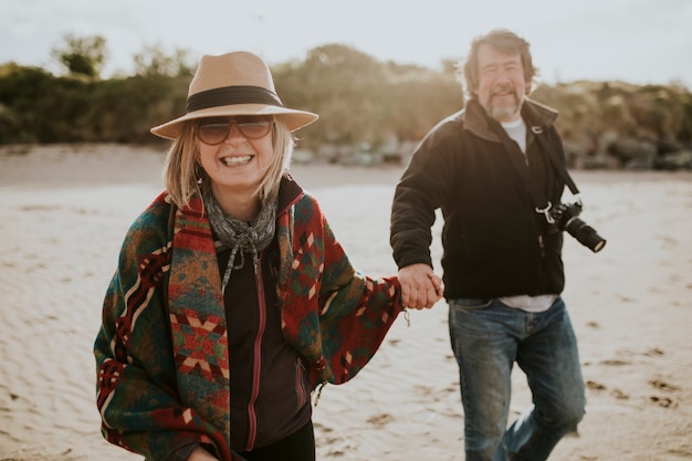 Gepensioneerd senior koppel dat van vakantie aan het strand geniet