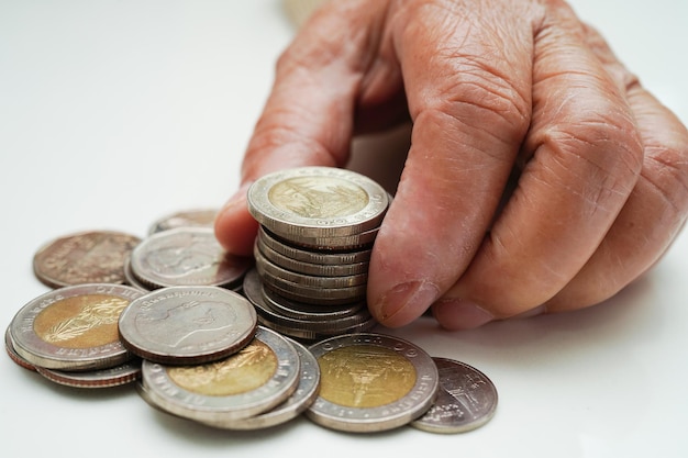 Gepensioneerde oudere vrouw die munten telt en zich zorgen maakt over maandelijkse uitgaven en betaling van behandelingskosten