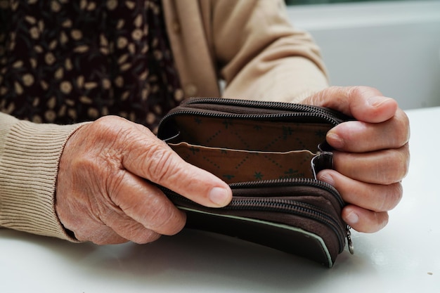 Gepensioneerde oudere vrouw die munten telt en zich zorgen maakt over maandelijkse uitgaven en betaling van behandelingskosten