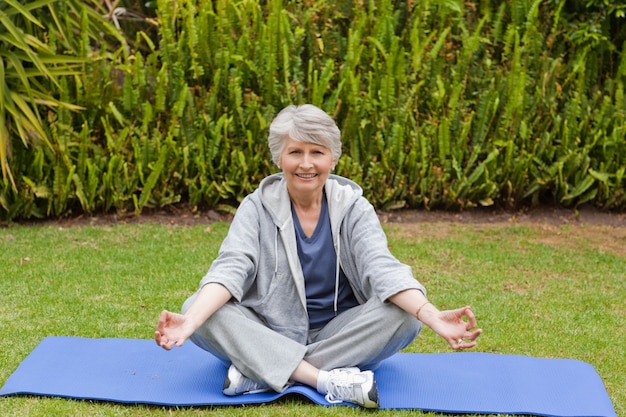 Gepensioneerde vrouw het beoefenen van yoga in de tuin