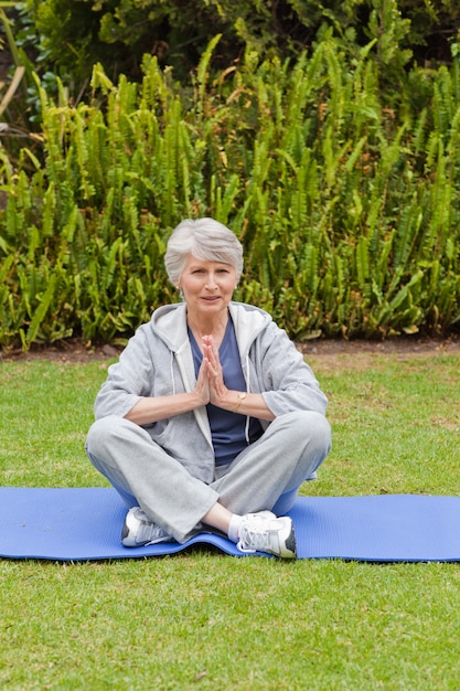 Gepensioneerde vrouw het beoefenen van yoga in de tuin