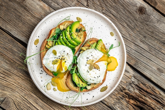 Gepocheerd ei op brood met spinazie, avocado en pompoenpitten Gezonde voeding keto dieet dieet lunch concept Bovenaanzicht