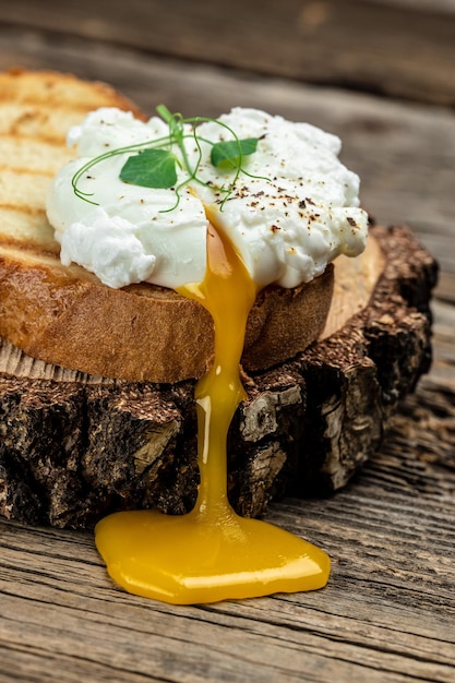 Gepocheerd ei op toast op de houten tafel Gezonde voeding keto dieet dieet lunch concept verticale afbeelding bovenaanzicht plaats voor tekst