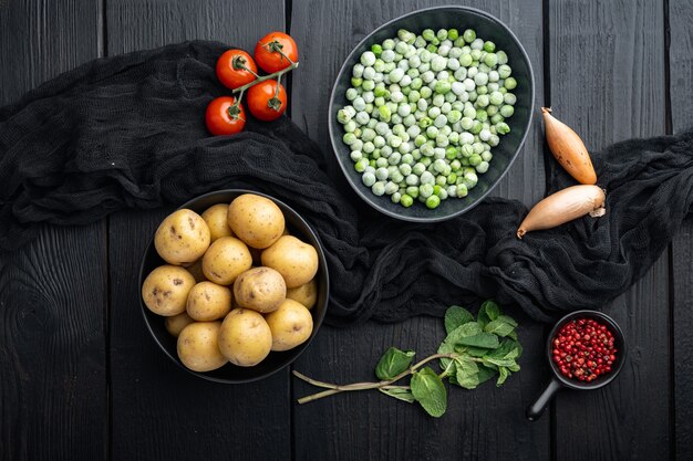 Gepureerde muntaardappelen ingrediënten, bovenaanzicht, op zwarte houten achtergrond