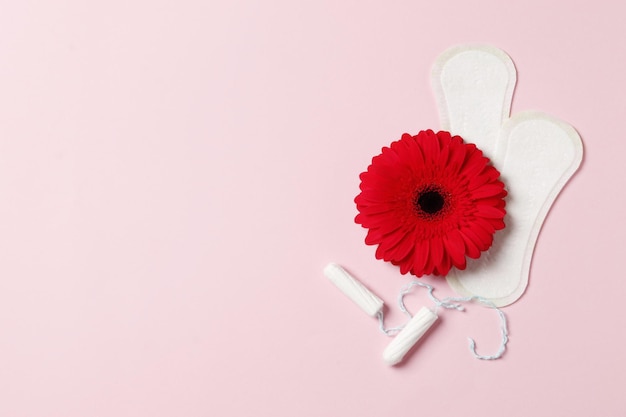 Photo gerbera pads and tampons on a pink background. ovulation concept. menstruation concept.