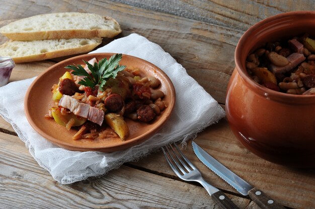 Gerecht gekookt in een pot met aardappelen, bonen, gerookt in een kleipot