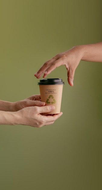 Foto gerecycled verpakkingsconcept barista een warme kop koffie geven aan klant zero waste materials milieuzorg hergebruik hernieuwbaar voor duurzame levensstijl verticaal beeld