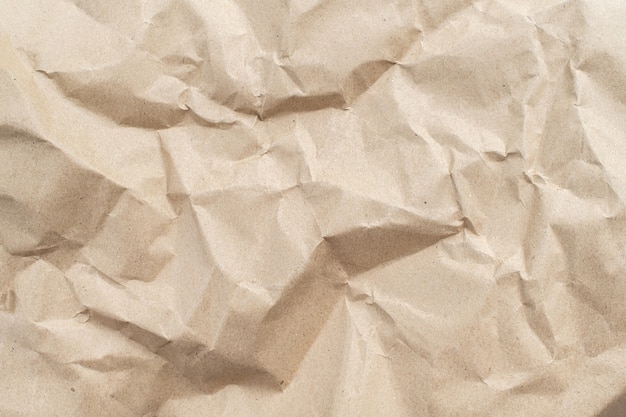 Gerecycleerde bruine gevouwen papieren achtergrond van een papieren verpakking. Verfrommeld bruin papier textuur concept