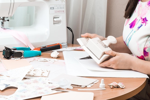 Gereedschap voor scrapbooking Een vrouw gebruikt gereedschap om papier te snijden