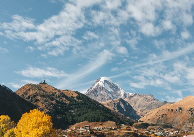 Gergeti Trinity Church bekend als Tsminda Sameba op de achtergrond van een bergkam en wolken, Stepantsminda, Kazbegi, Georgia.