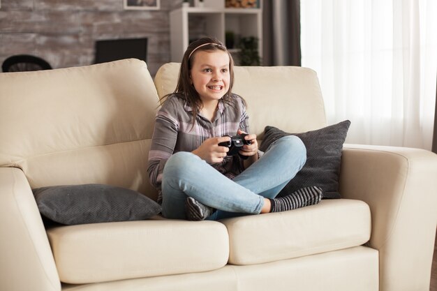 Gericht meisje met beugels die videogames spelen met behulp van draadloze joystick.