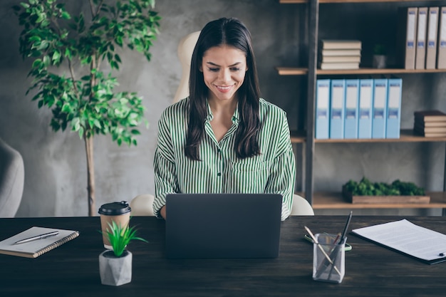 Gerichte dame freelancer zitten bureau op kantoor kijken in laptop scherm