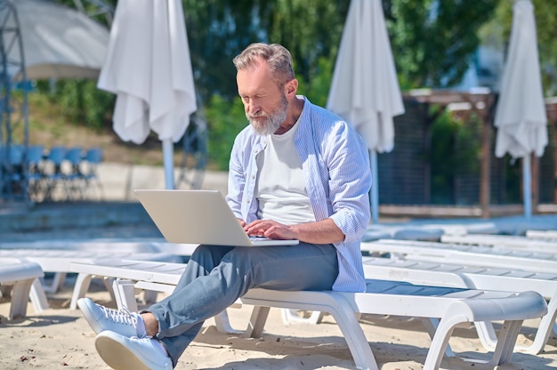 Gerichte man aan het werk op laptop buitenshuis