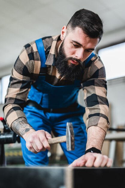 Gerichte professionele timmerman die werkt in zijn werkplaats, houtbewerking en vakmanschapconcept.