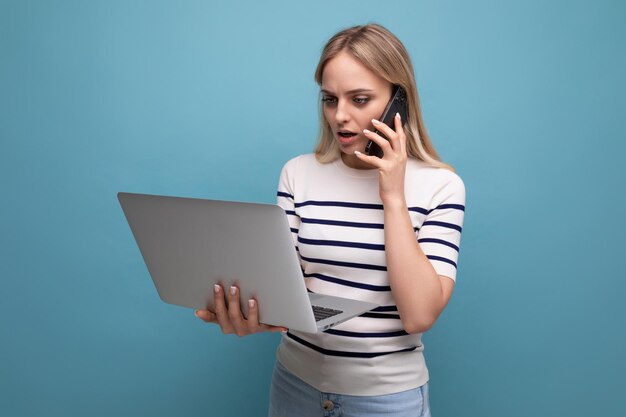 Gerichte zakenvrouw praten aan de telefoon en laptop vasthouden op blauwe achtergrond