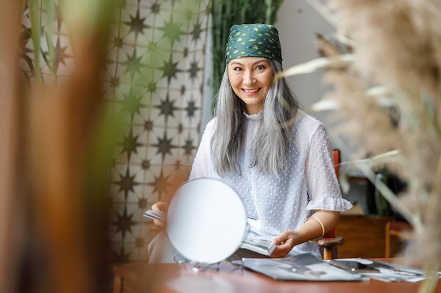 Gerijpte mooie Aziatische vrouw met bleek haar thuis