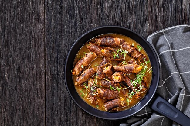 Photo german beef rouladen in thick gravy on pan