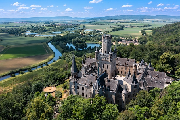 German castle Marienburg immersed in the greenery of the forest not far from Hannover Aerial view of a medieval romantic castle