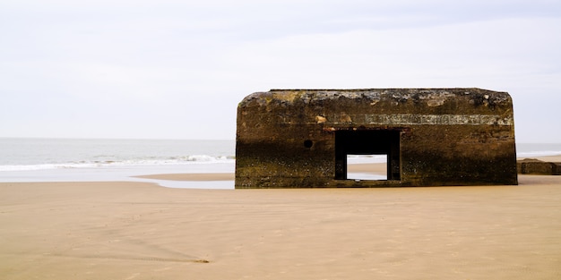 Foto vecchio blockhaus tedesco in spiaggia di sabbia nella capanna francese della costa atlantica wwii